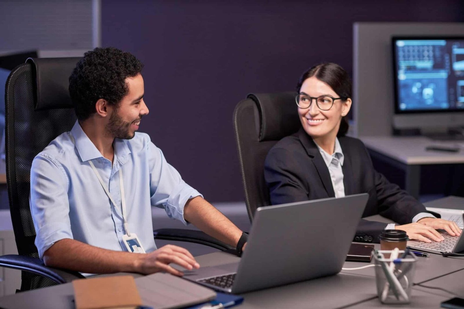 Two smiling business professionals discussing a project at our digital services company